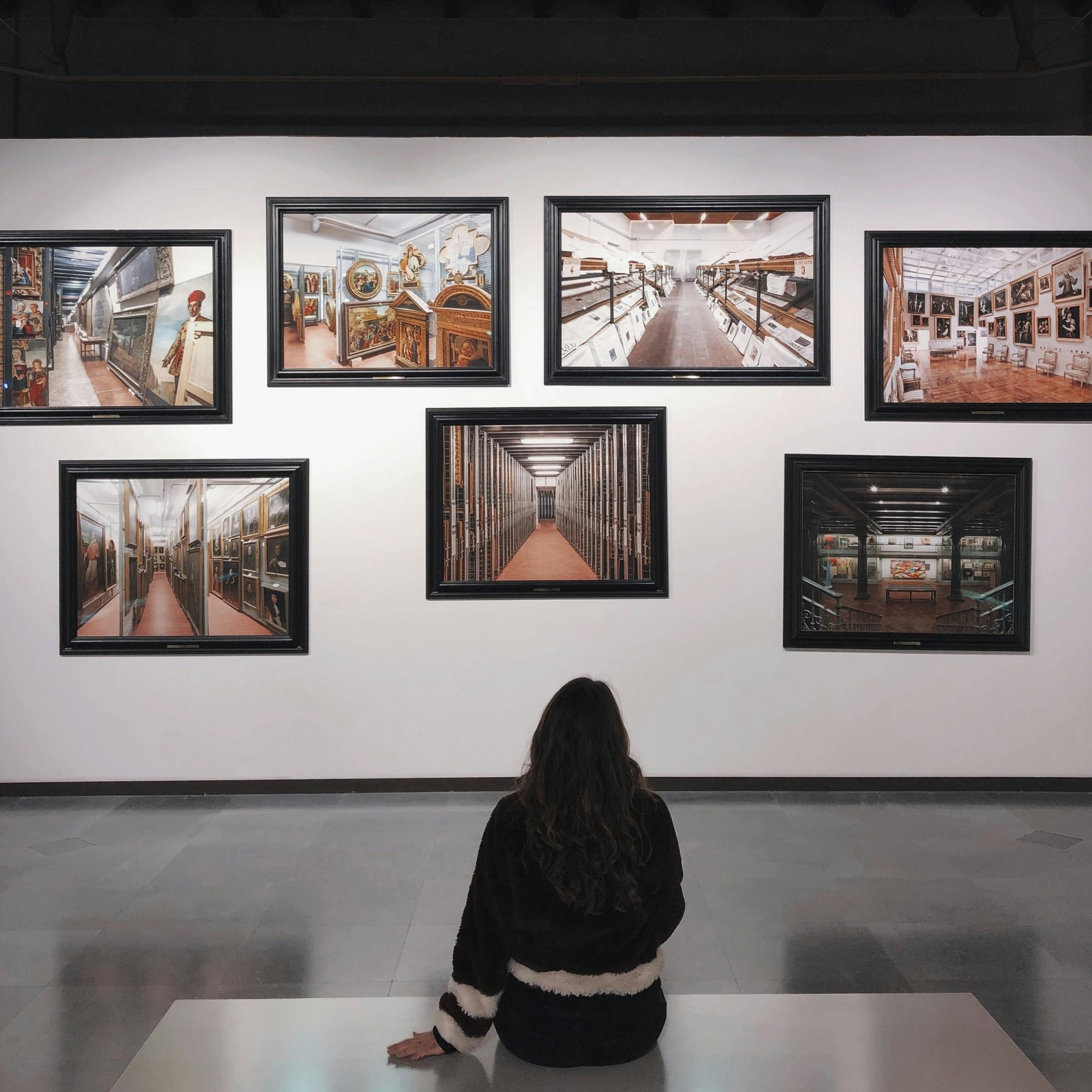 Woman viewing framed artwork in a gallery