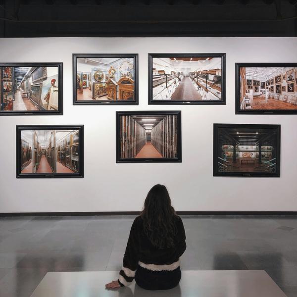Woman viewing framed artwork in a gallery