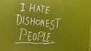 On a sickly-green colour toilet door, written in an almost glowing white, in pretty neat writing: 'I hate dishonest people'.