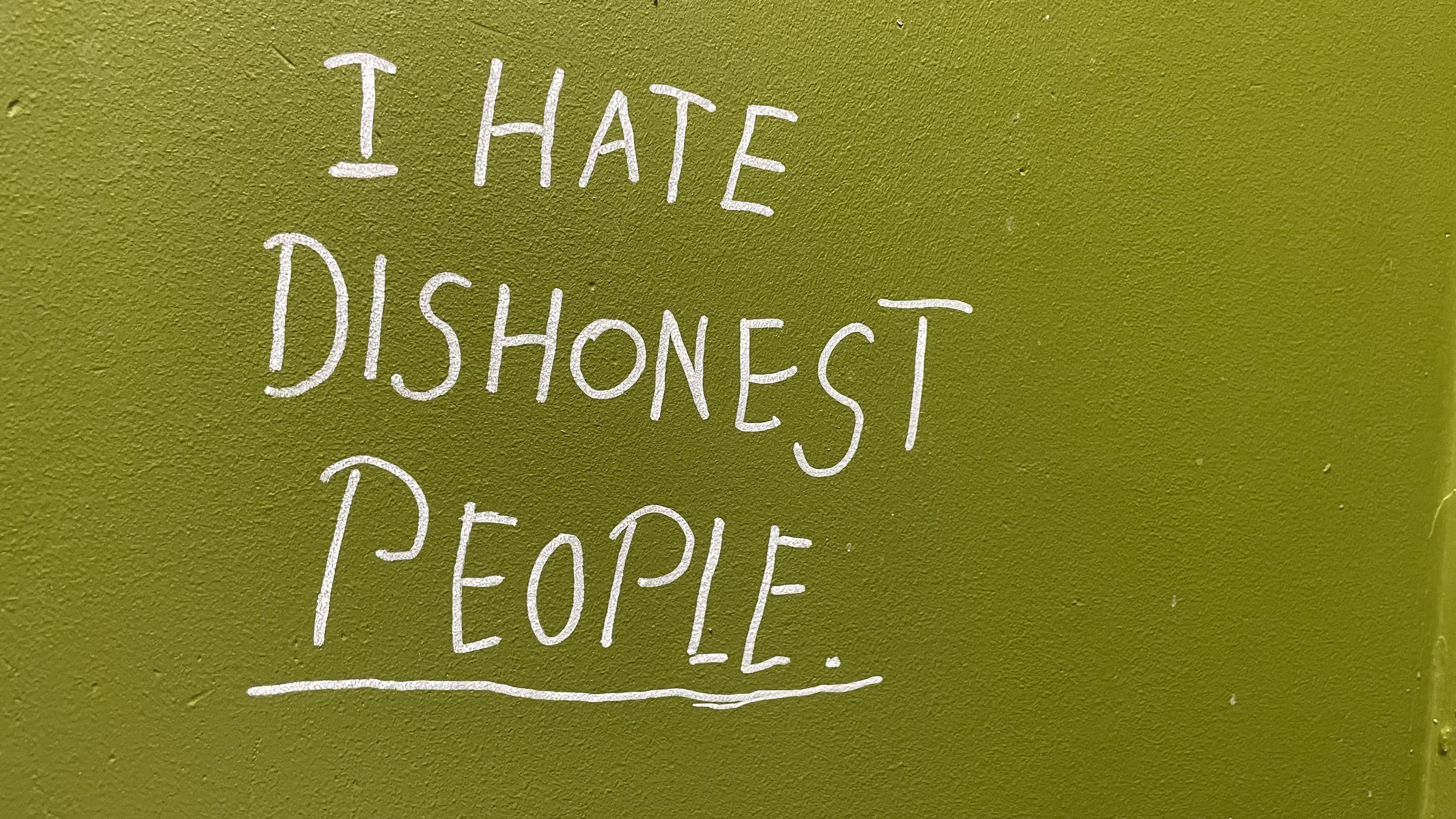 On a sickly-green colour toilet door, written in an almost glowing white, in pretty neat writing: 'I hate dishonest people'.
